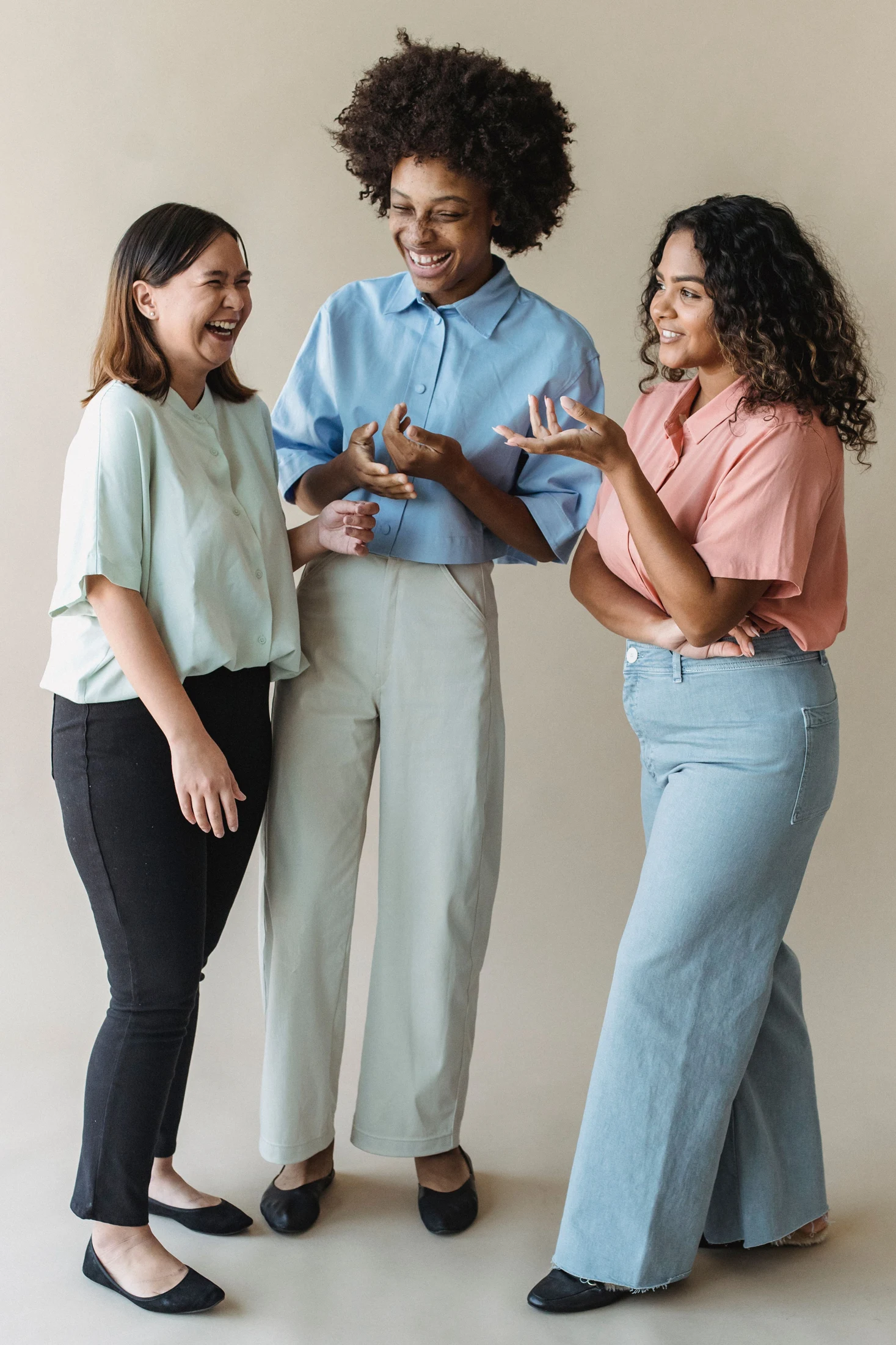 Three women sharing a joyful conversation